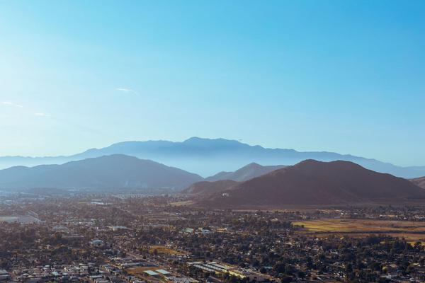 A stunning aerial view of mountains embracing the city under a blue sky